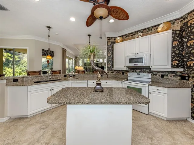 a large kitchen with stainless steel appliances kitchen island granite countertop a lot of counter space and a sink