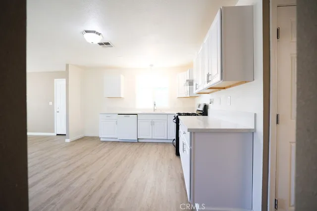 a kitchen with a sink cabinets and wooden floor