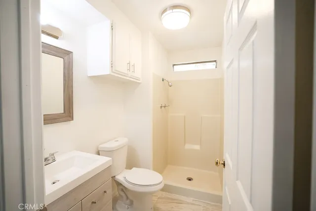 a bathroom with a sink a toilet and shower