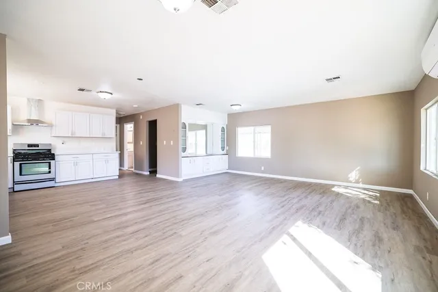 a view of empty room with wooden floor and window
