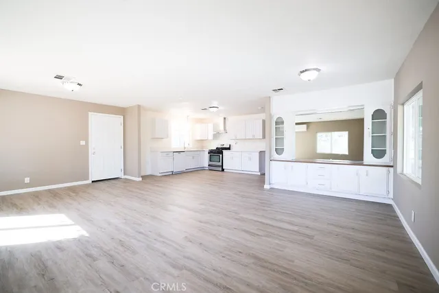 a view of empty room with wooden floor and windows