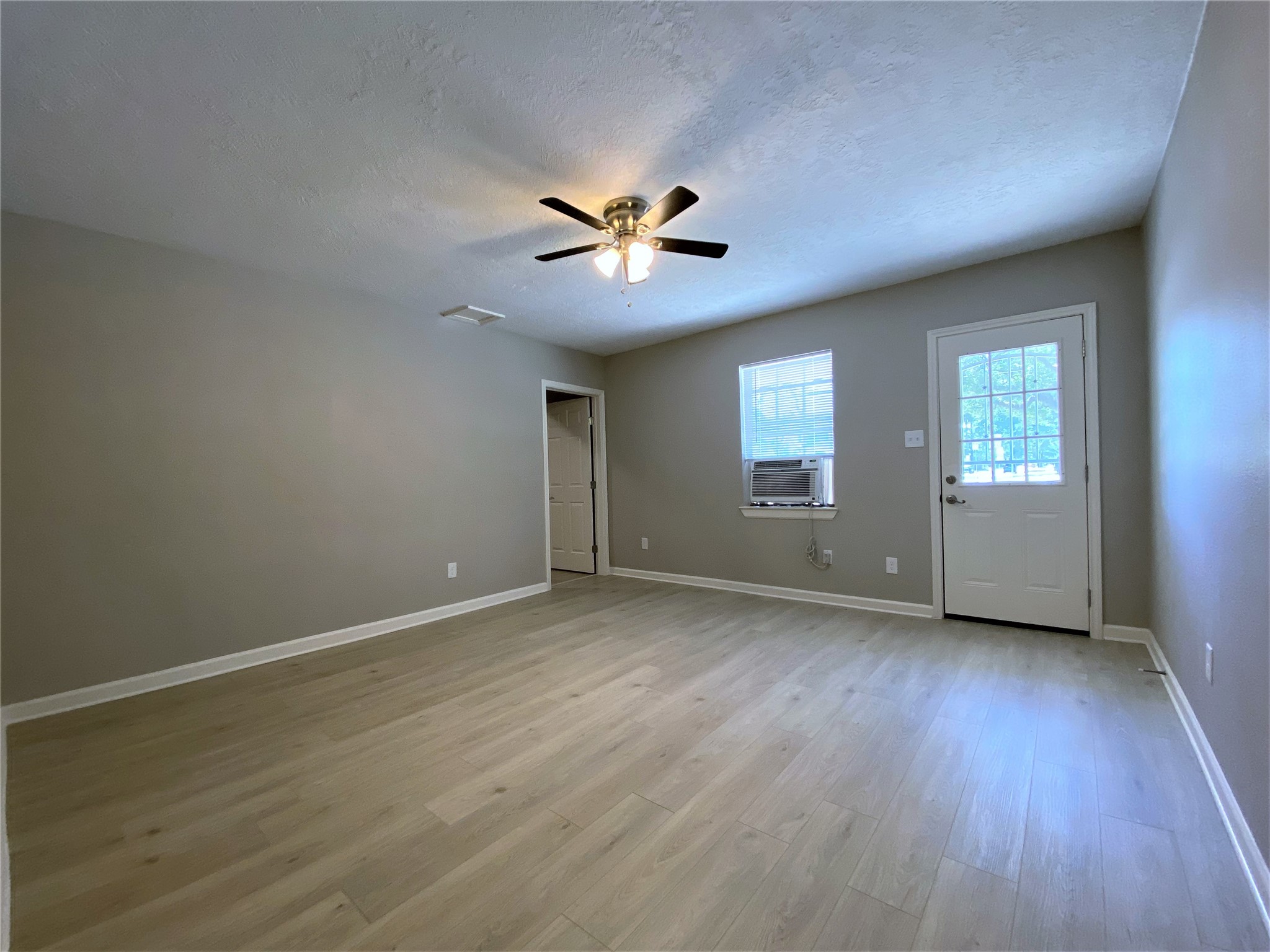 1702 Studewood Street Houston, TX 77009 - Photo 9 of 11 The living room is in the front of the apartment. The door on the left opens into the front bedroom.