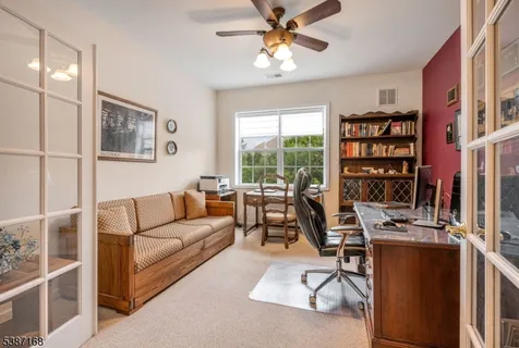 a living room with furniture a bookshelf and a window