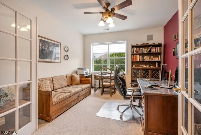 a living room with furniture a bookshelf and a window