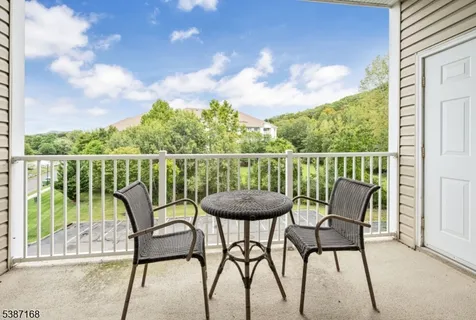 a view of a chairs and table in the balcony