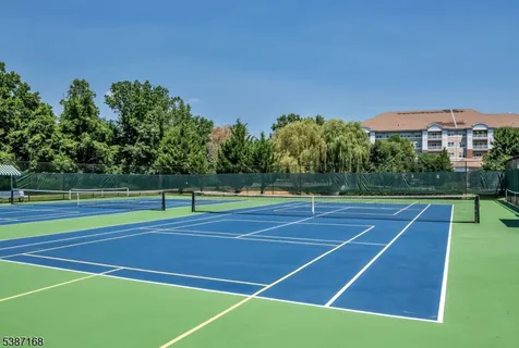 a view of a swimming pool with a yard and large trees