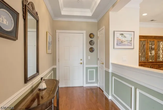 a view of a hallway with entryway and wooden floor