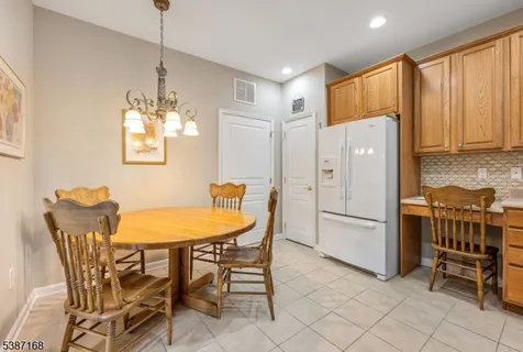 a kitchen with stainless steel appliances a table chairs and refrigerator
