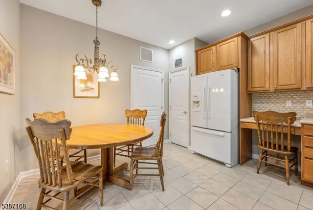a kitchen with stainless steel appliances a table chairs and refrigerator