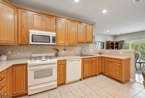 a kitchen with granite countertop cabinets stainless steel appliances and a window