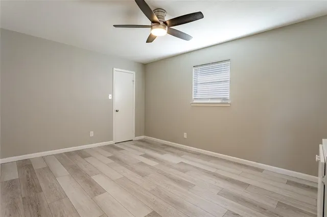 an empty room with a window and a fan