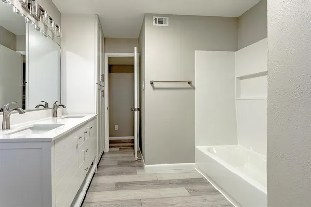 a bathroom with a tub sink and mirror