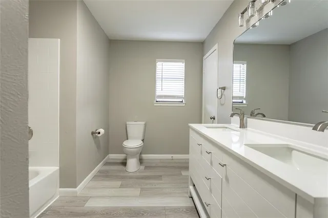 a bathroom with a sink a toilet and a large mirror