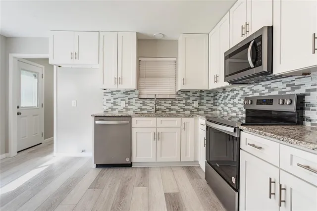 a kitchen with stainless steel appliances granite countertop a sink stove and microwave