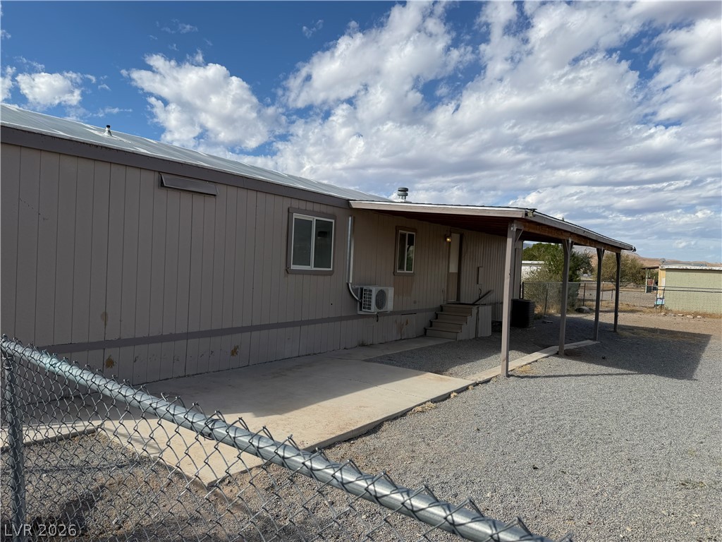 4360 Retread Road Pahrump, NV 89048 - Photo 15 of 19 A covered patio and concrete walkway sit adjacent to this residential structure.