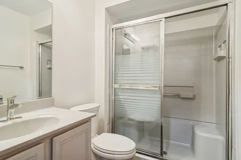 a bathroom with a granite countertop sink toilet and shower