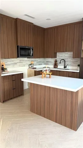 a kitchen with stainless steel appliances granite countertop a sink dishwasher stove and cabinets with wooden floor