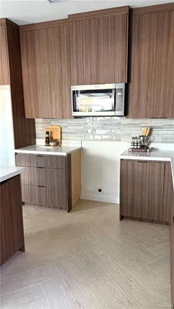 a kitchen with kitchen island granite countertop wooden cabinets a sink a stove and a refrigerator