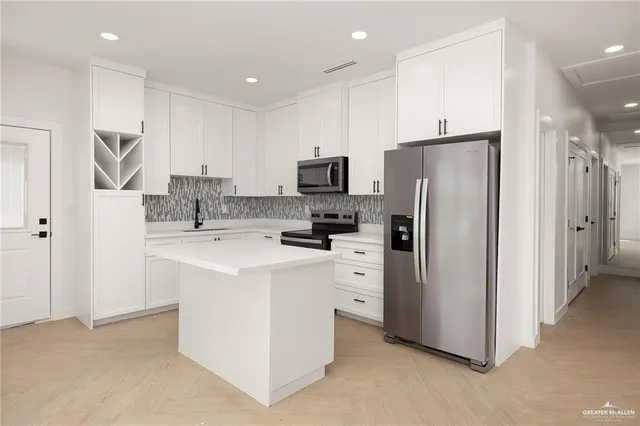 a kitchen with stainless steel appliances a refrigerator stove microwave and sink