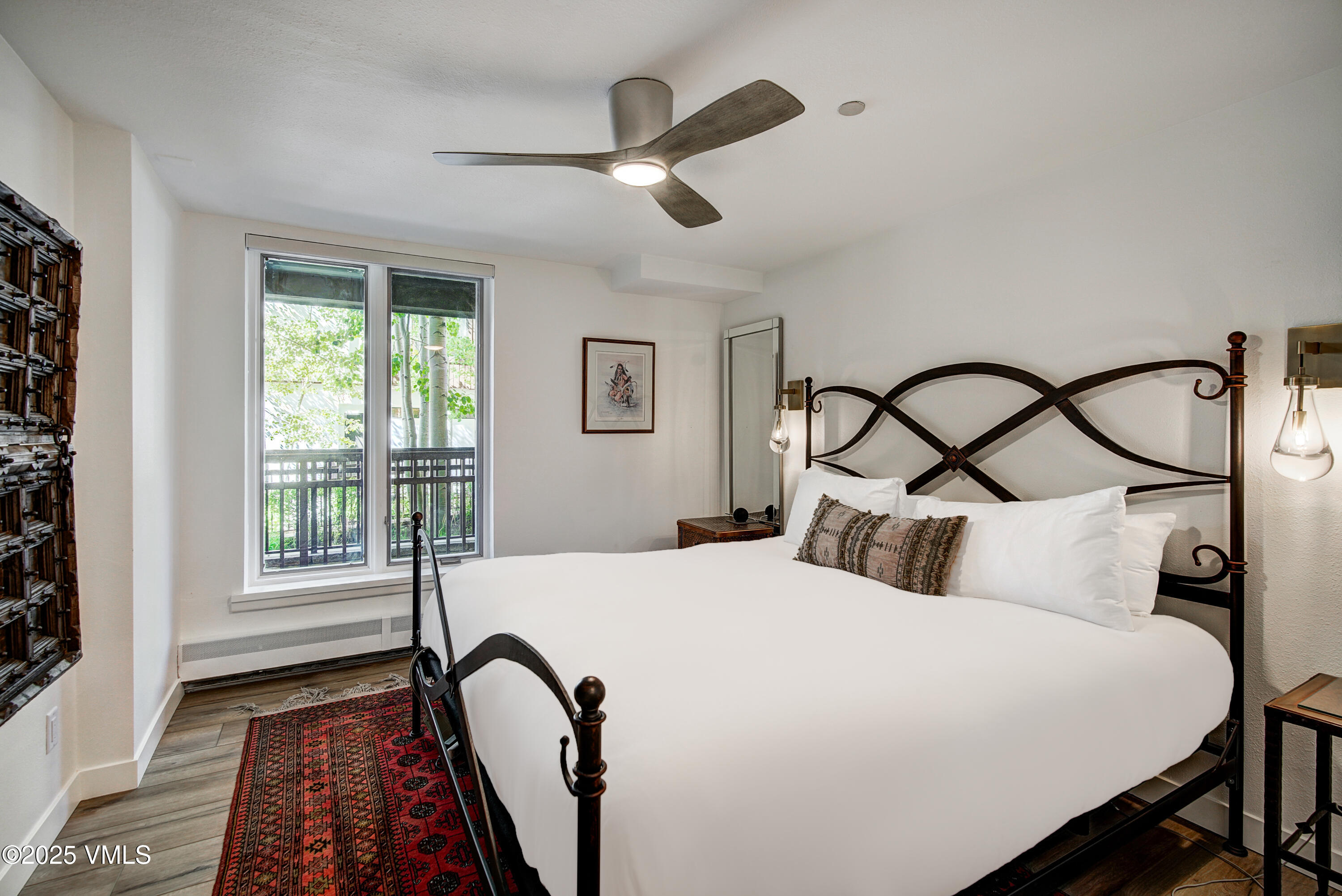 120 Willow Bridge Road, Unit 2H Vail, CO 81657 - Photo 7 of 15 a bedroom with a bed next to a window with a chandelier