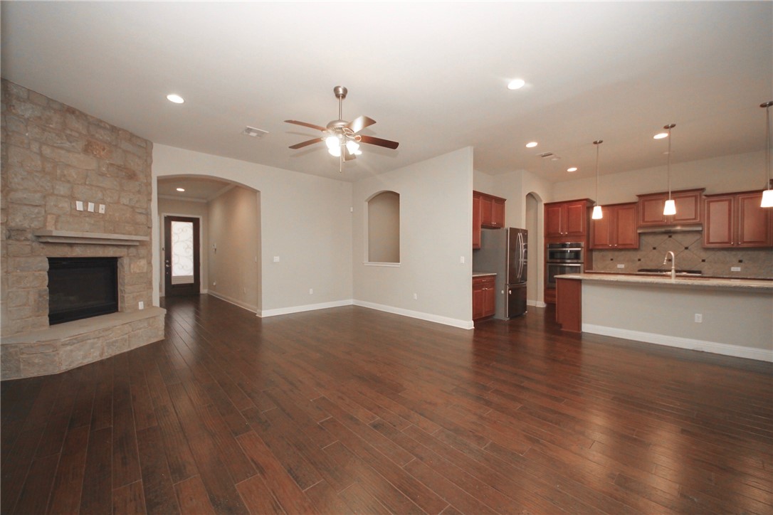 15800 Jeffs Lane Austin, TX 78717 - Photo 4 of 17 a view of an empty room and kitchen with fireplace wooden floor and cabinet