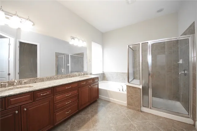 a bathroom with a granite countertop bathtub shower sink and mirror