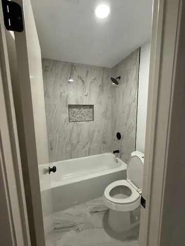 a bathroom with a toilet and a bathtub