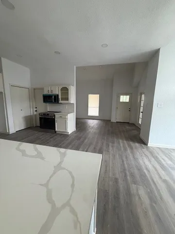 a view of a kitchen with furniture and wooden floor