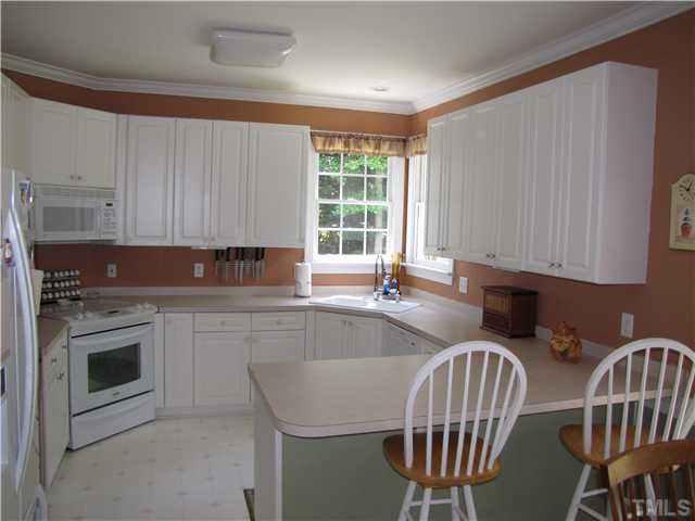 12101 Old Creedmoor Road Raleigh, NC 27613 - Photo 3 of 25 a kitchen with stainless steel appliances granite countertop a sink a stove a microwave cabinets and a dining table