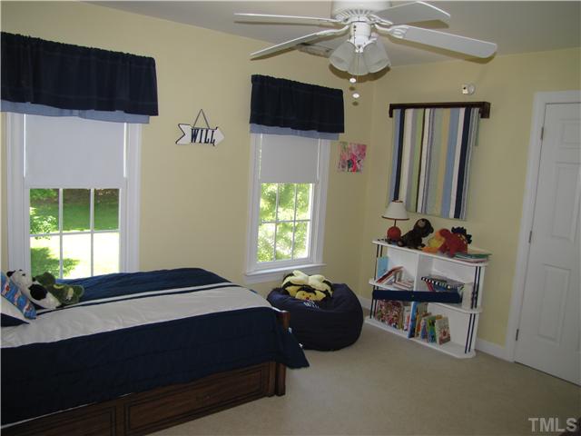 12101 Old Creedmoor Road Raleigh, NC 27613 - Photo 10 of 25 a bedroom with a bed a flat screen tv and a window