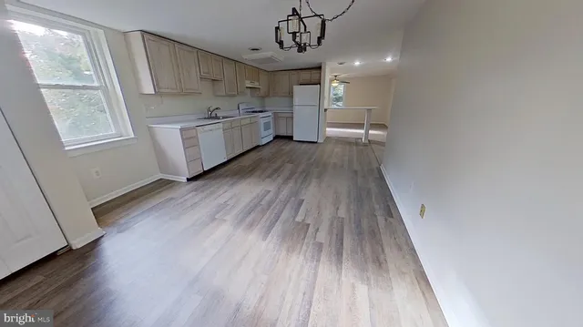 a kitchen with wooden floors and wooden cabinets