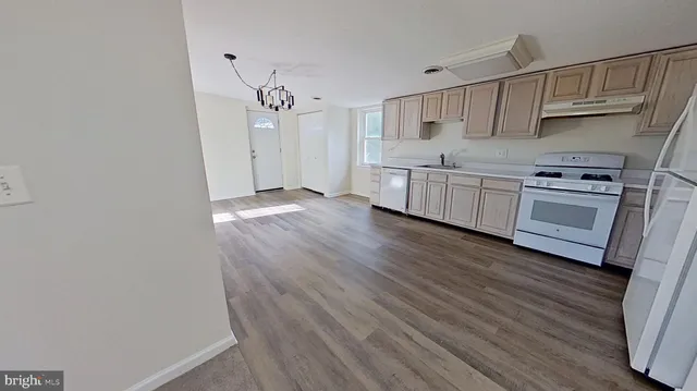 a kitchen with cabinets wooden floor and stainless steel appliances