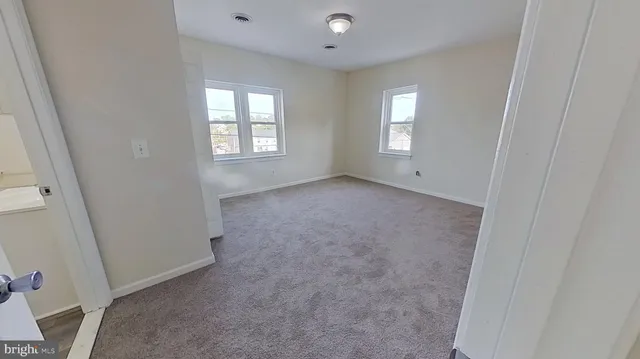 an empty room with windows and closet