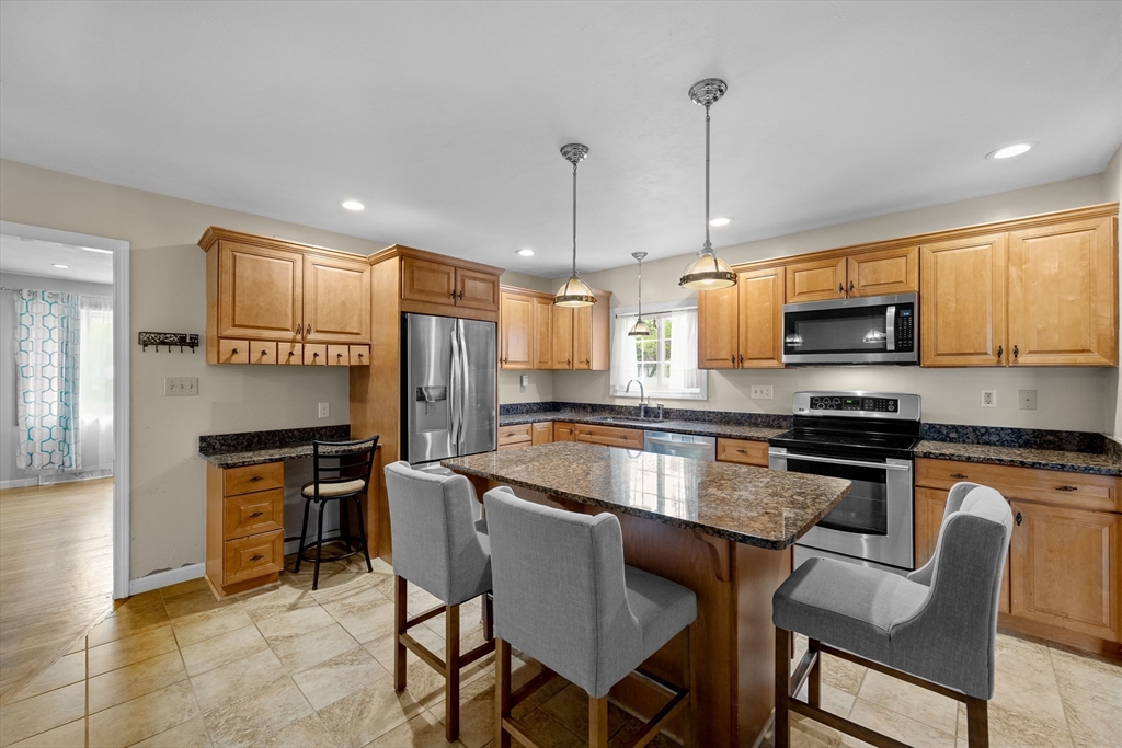 46 Wing Lane Acushnet, MA 02743 - Photo 11 of 38 a kitchen with a table chairs microwave and refrigerator
