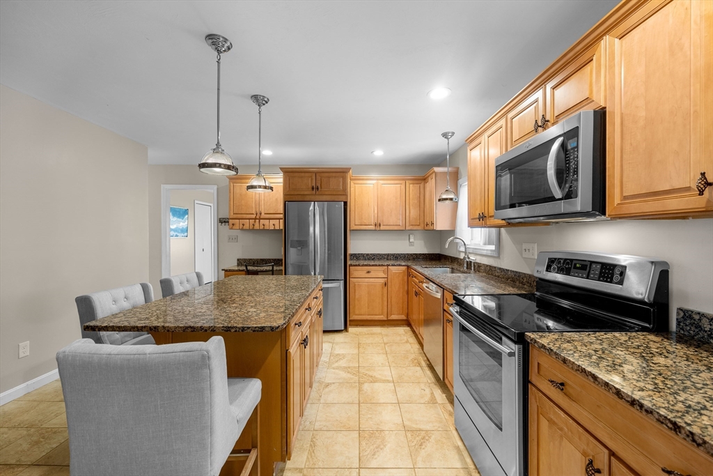 46 Wing Lane Acushnet, MA 02743 - Photo 12 of 38 a kitchen with stainless steel appliances granite countertop a sink a stove and a wooden cabinets