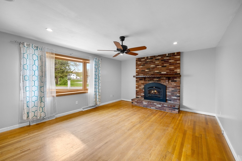 46 Wing Lane Acushnet, MA 02743 - Photo 9 of 38 a view of empty room with fireplace and wooden floor