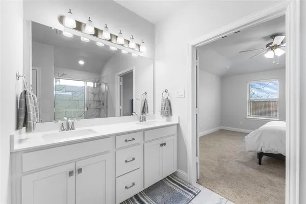 a spacious bathroom with a double vanity sink a mirror and a shower