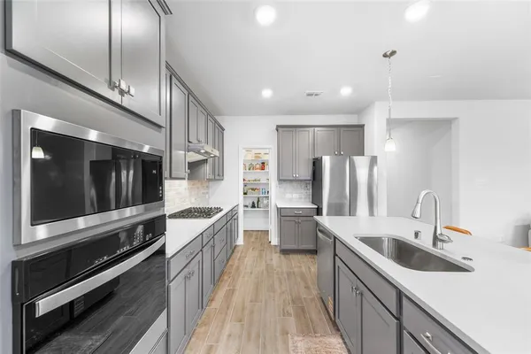 a kitchen with stainless steel appliances kitchen island granite countertop a sink and a stove