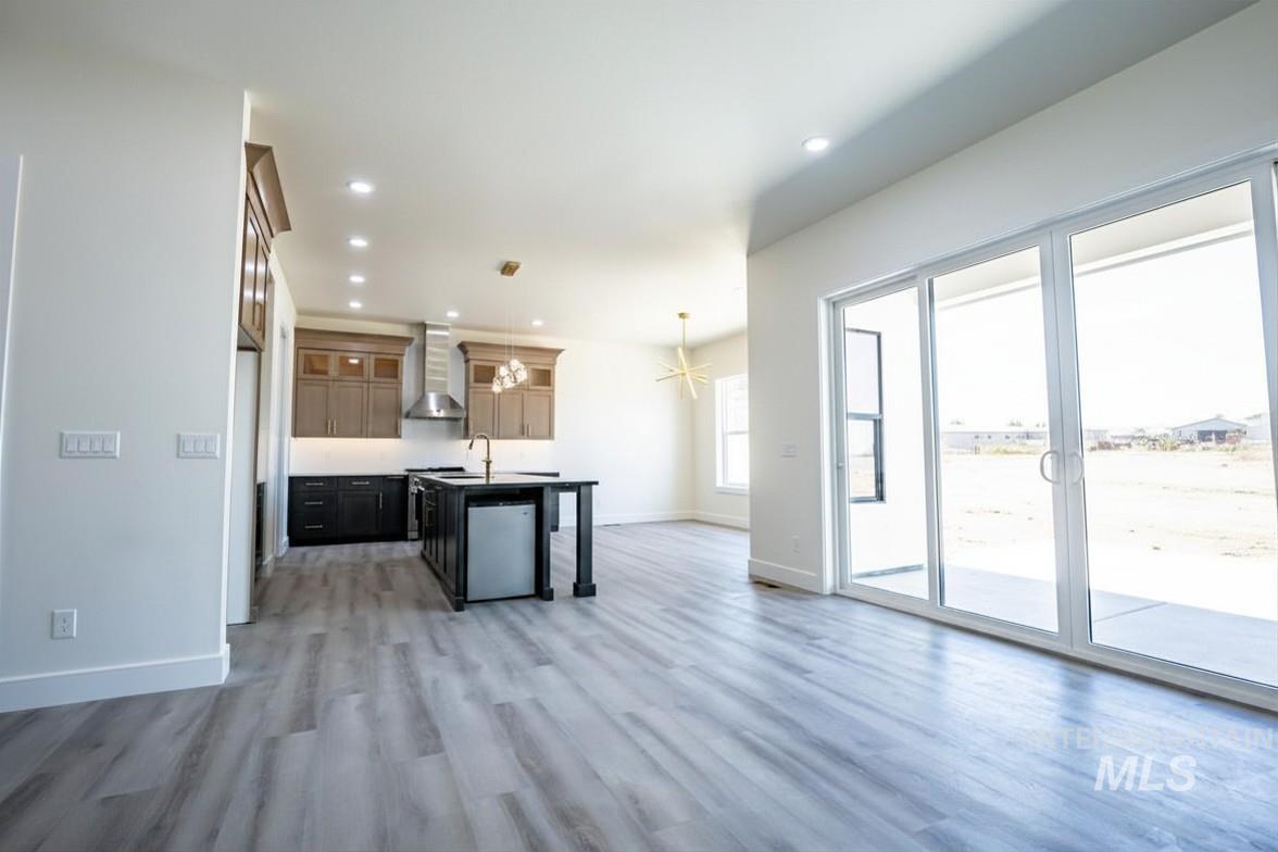 23904 Southview Lane Middleton, ID 83644 - Photo 6 of 29 Open-concept living space featuring wood-finish flooring, recessed lighting, and a modern kitchen with two-tone cabinetry and stainless steel appliances