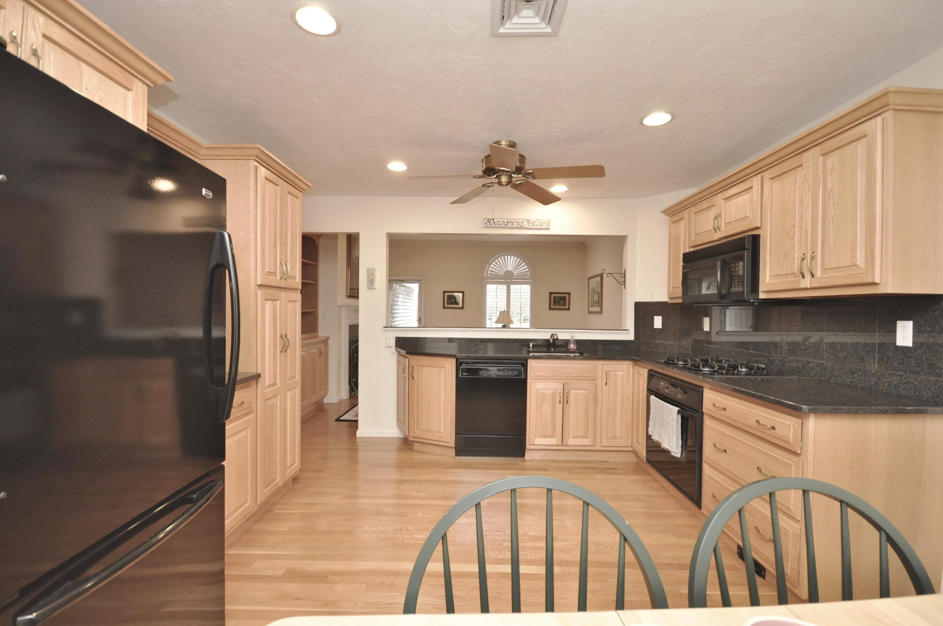 4 Oakbluff Road Sagamore Beach, MA 02562 - Photo 1 of 35 a kitchen with stainless steel appliances granite countertop a refrigerator a stove and a sink with wooden floor