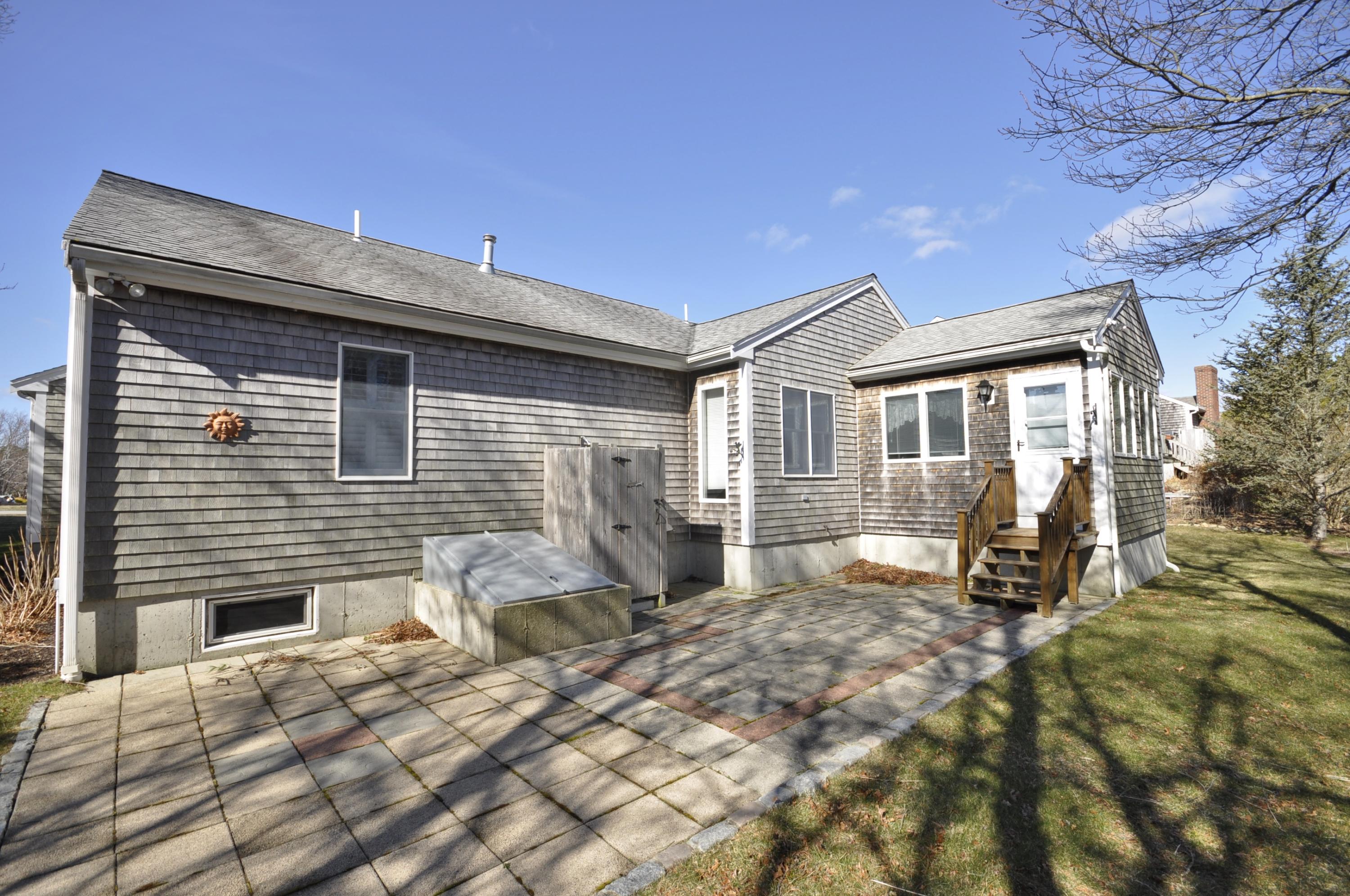 4 Oakbluff Road Sagamore Beach, MA 02562 - Photo 35 of 35 a backyard of a house with table and chairs