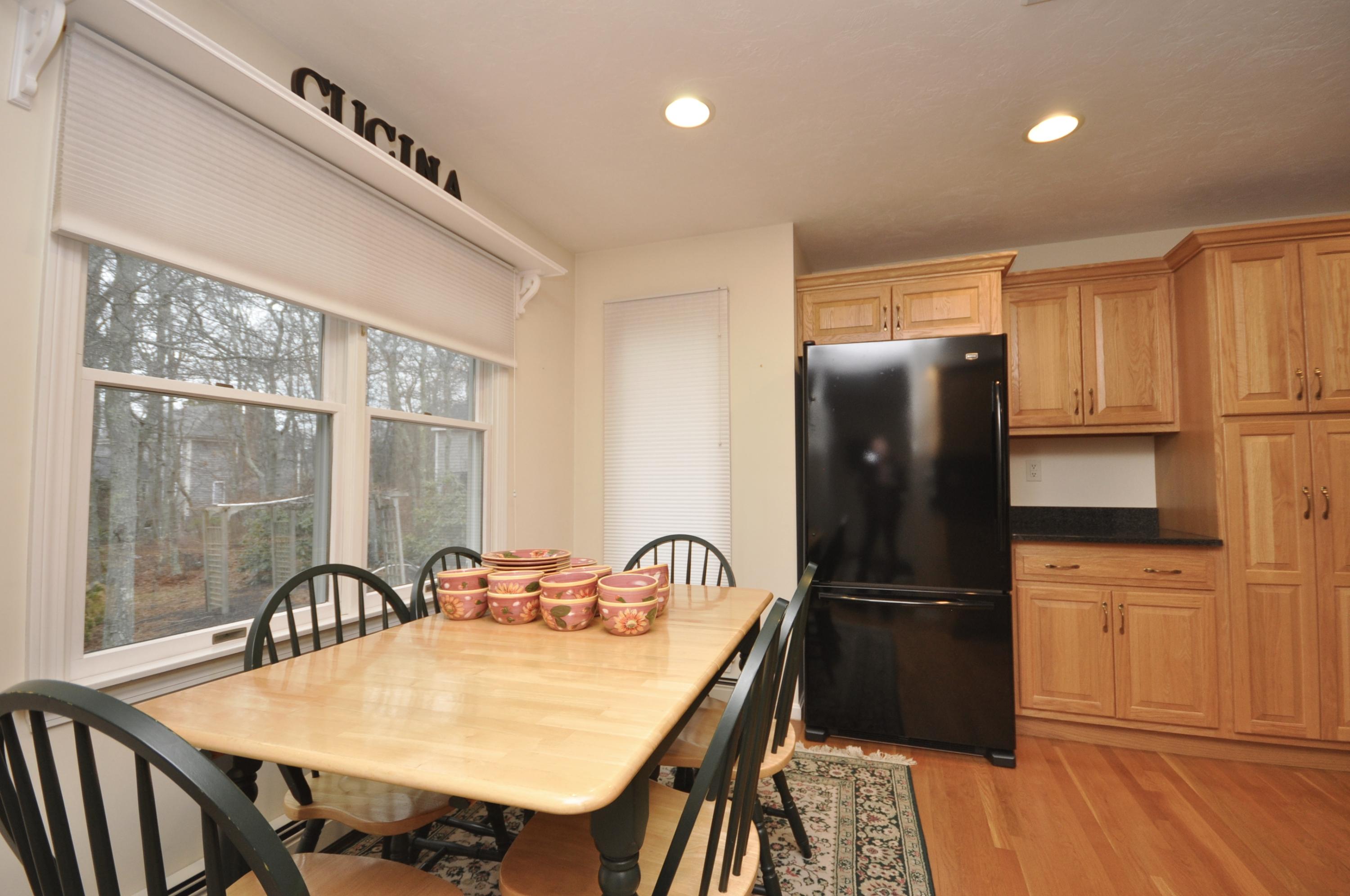 4 Oakbluff Road Sagamore Beach, MA 02562 - Photo 5 of 35 a kitchen with granite countertop a refrigerator a stove and a dining table with wooden floor