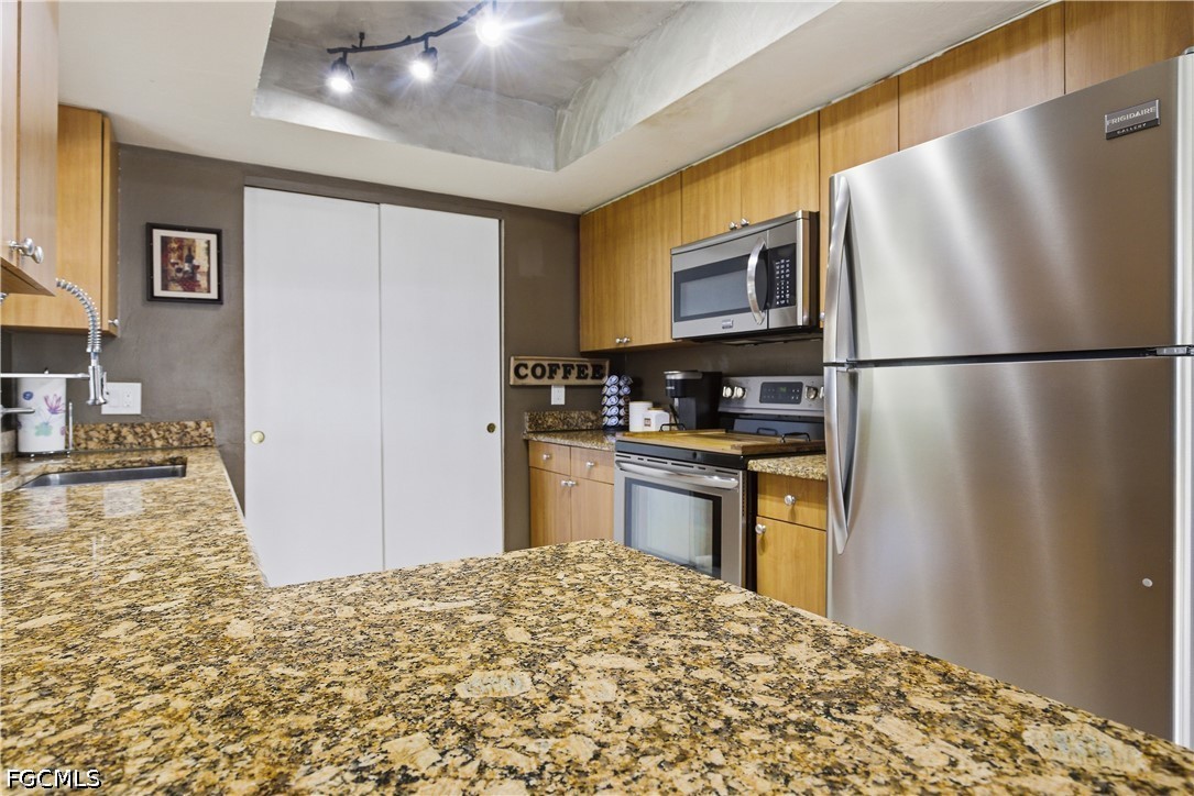 4960 20th Place Southwest Naples, FL 34116 - Photo 10 of 33 a kitchen with granite countertop a refrigerator and a sink