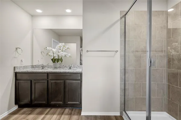 a bathroom with a granite countertop sink a mirror and shower