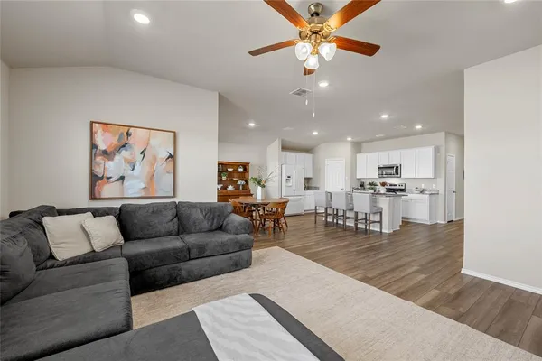 a living room with furniture kitchen view and a chandelier