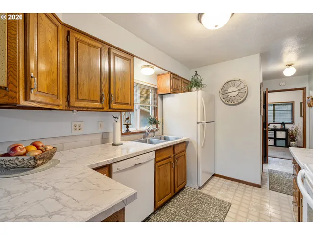 a kitchen with stainless steel appliances granite countertop a refrigerator a stove and a sink