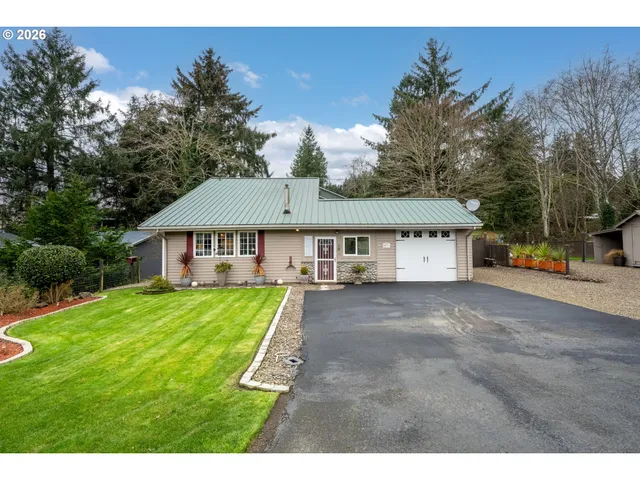 a view of a yard in front of a house with large tree