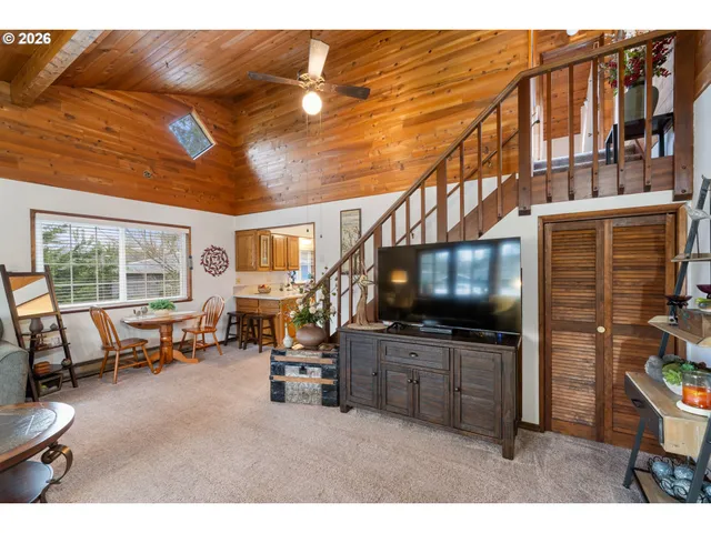 a living room with furniture a flat screen tv and floor to ceiling window