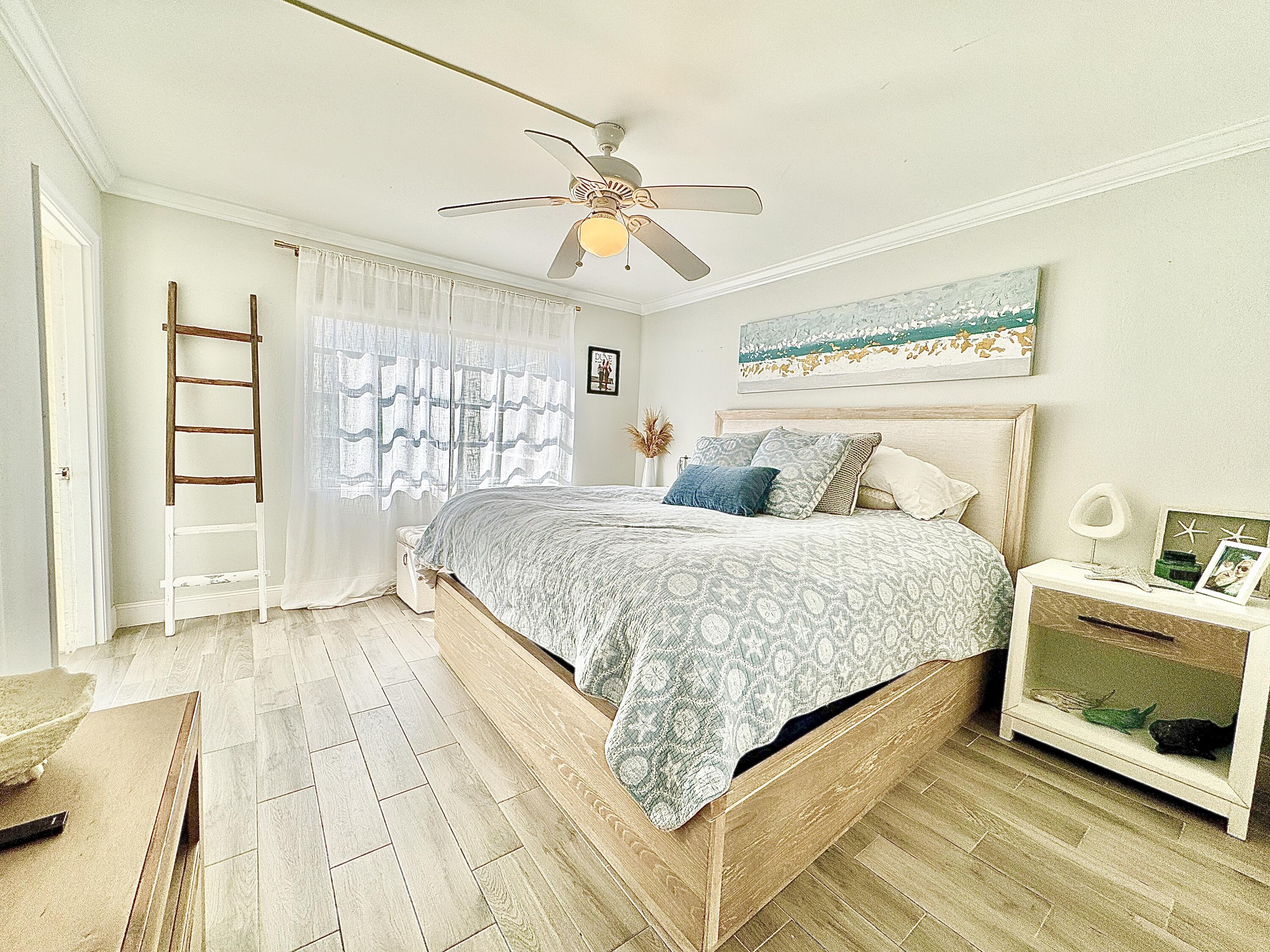 2871 North Ocean Boulevard, Unit R248 Boca Raton, FL 33431 - Photo 9 of 44 a bedroom with a bed and a chandelier