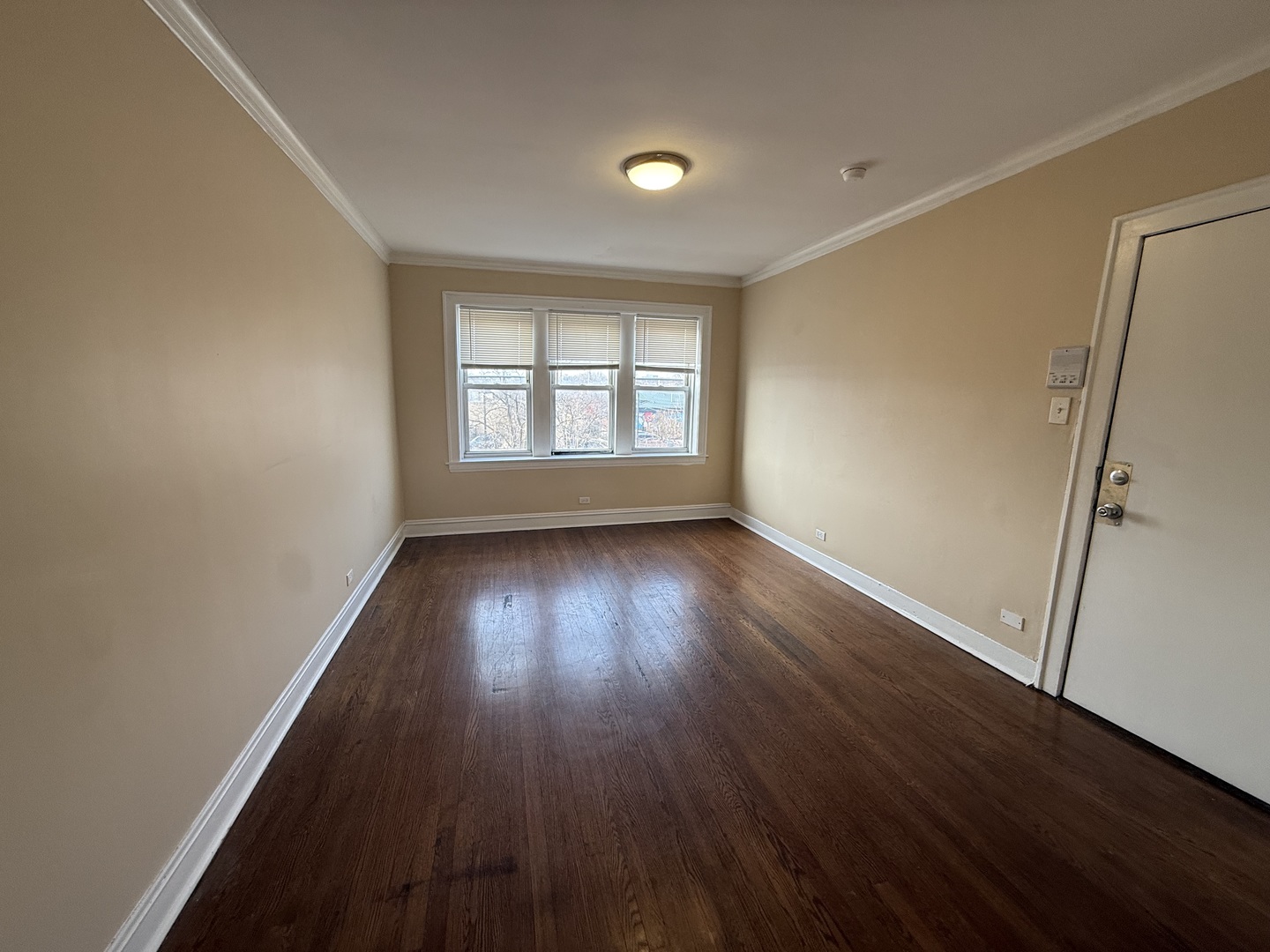 2805 North Kilbourn Avenue, Unit 3S Chicago, IL 60639 - Photo 2 of 13 an empty room with wooden floor and windows